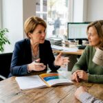 Ein Immobilienverwalter empfängt Kunden zu einem persönlichen Gespräch in seinem Büro.