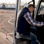 Während der Fahrerschulung werden die Außenspiegel des Lkw sorgfältig von Hand eingestellt.