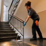 Putzkraft wischt die Treppenstufen im Mehrfamilienhaus