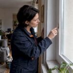 Hausverwalterin kontrolliert Fenster in der Mietwohnung